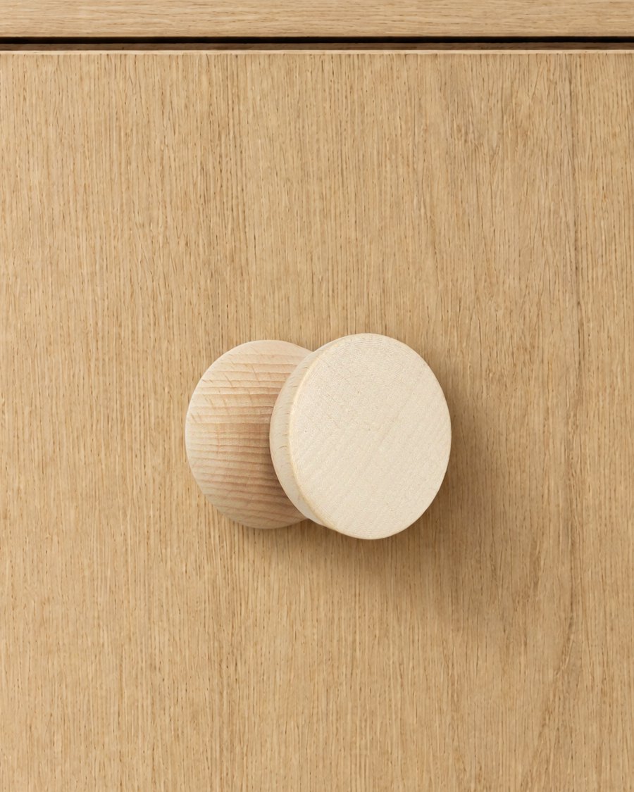 One beech wood hook fixed to a light oak cabinet door as a knob