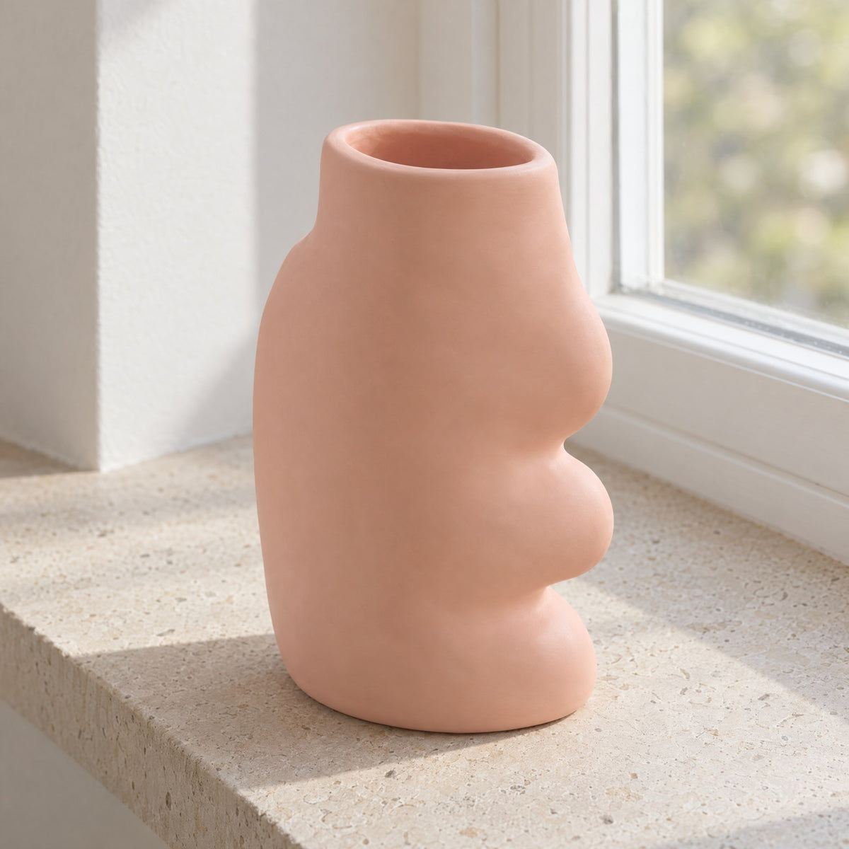 Fluxo large pink ceramic vase, empty, on a limestone windowsill, seen from above to show its oval mouth