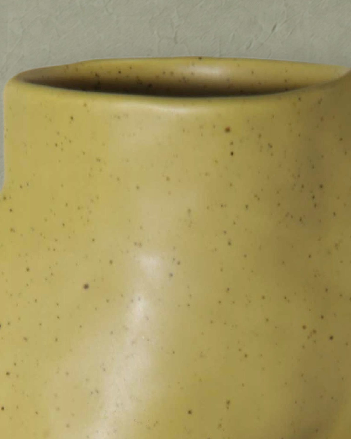 Close-up of the rounded rim and speckled pistachio green glaze of the Fluxo large vase