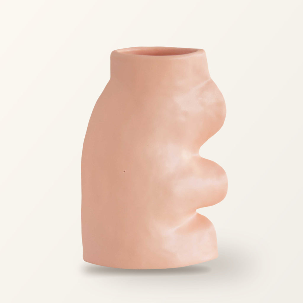 Fluxo large ceramic vase in pink with a wavy side, on a plain warm-white backdrop