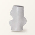Fluxo medium ceramic vase in white with a wavy side, on a plain warm-white backdrop