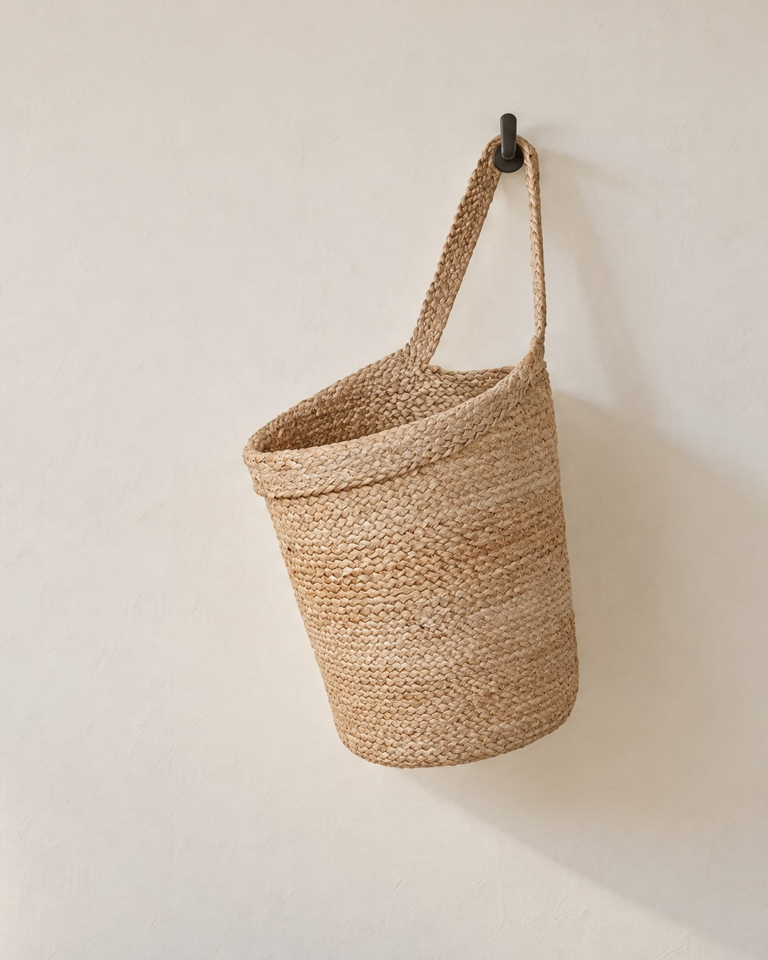 Kata braided jute wall basket hanging on a warm white wall (hook not included)