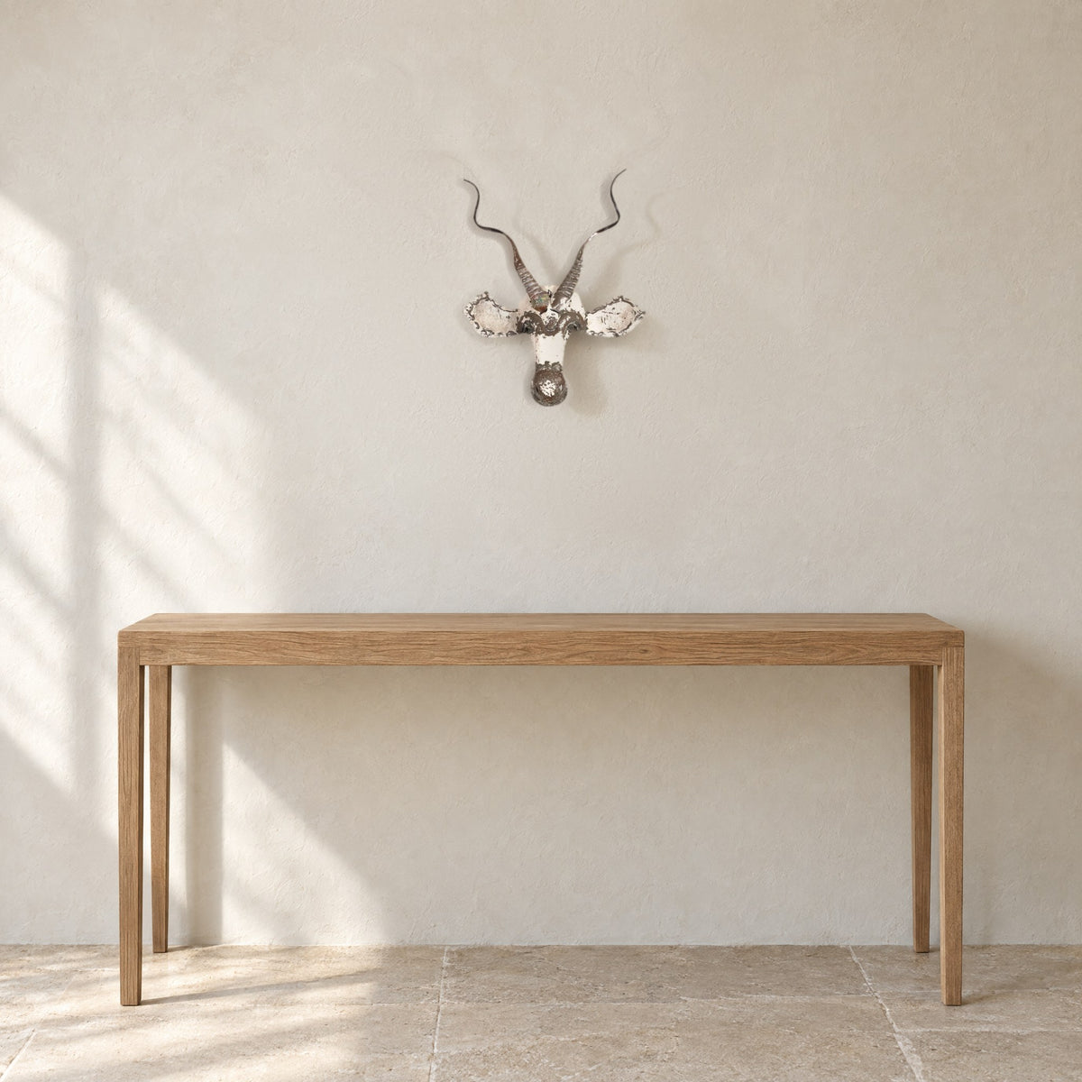 Kudu recycled metal wall mask on a pale limewash wall above a long oak console table