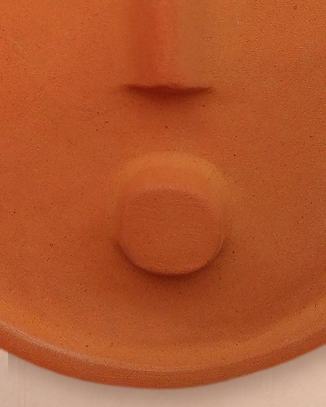 Close-up of the round chin detail and matte glaze of the terracotta mask