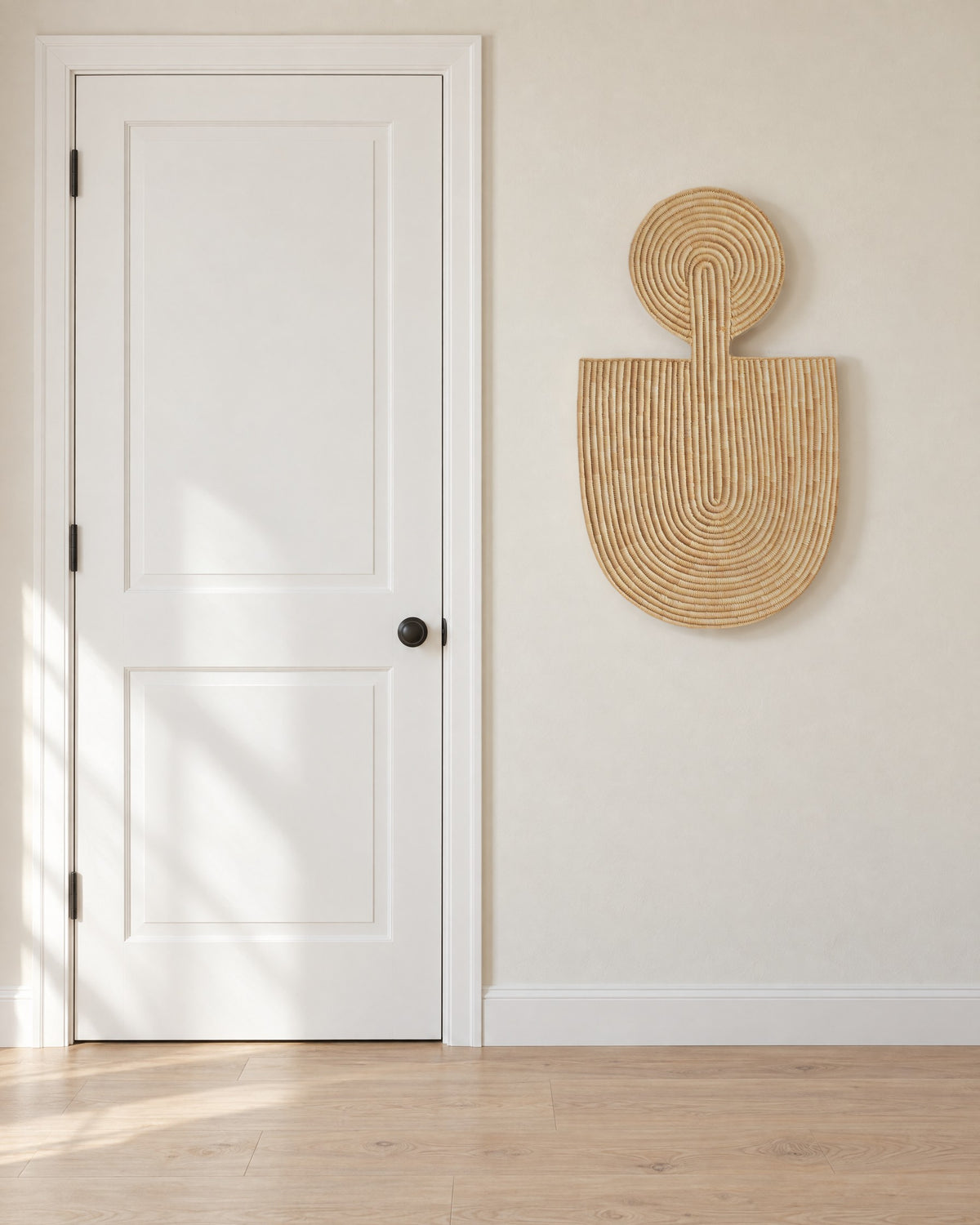Abstract Wall Mask 1 hung on an off-white entry wall beside a white panel door