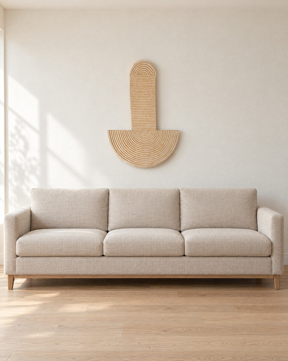 Abstract Wall Mask 3 hung on a warm white wall above a plain oatmeal linen sofa