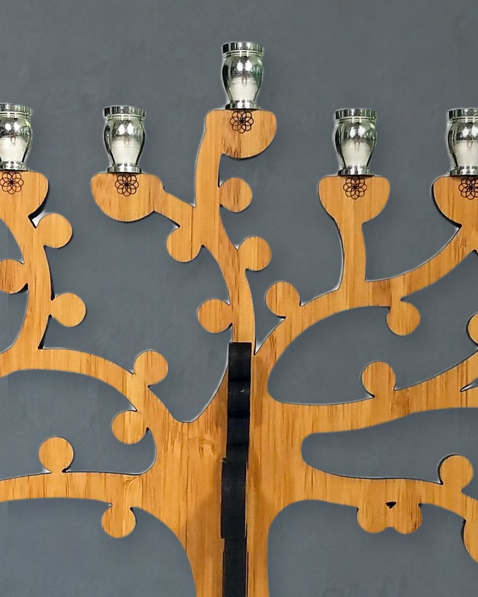 Close-up of the menorah's nickel candle cups on amber bamboo branches, the center cup raised