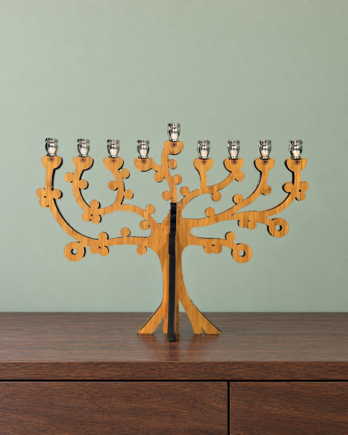 Tree of Life bamboo menorah on a walnut sideboard against a soft sage-green wall