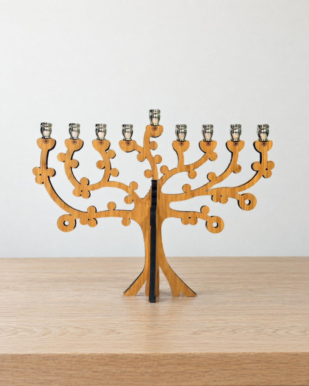Tree of Life bamboo menorah standing on a pale oak table against a warm white wall