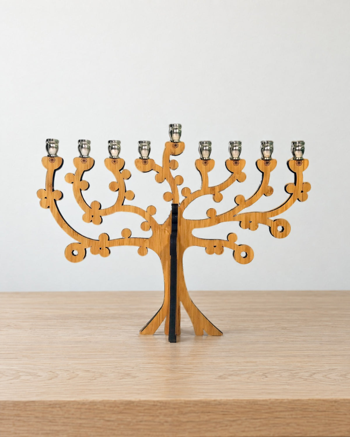 Tree of Life bamboo menorah standing on a pale oak table against a warm white wall