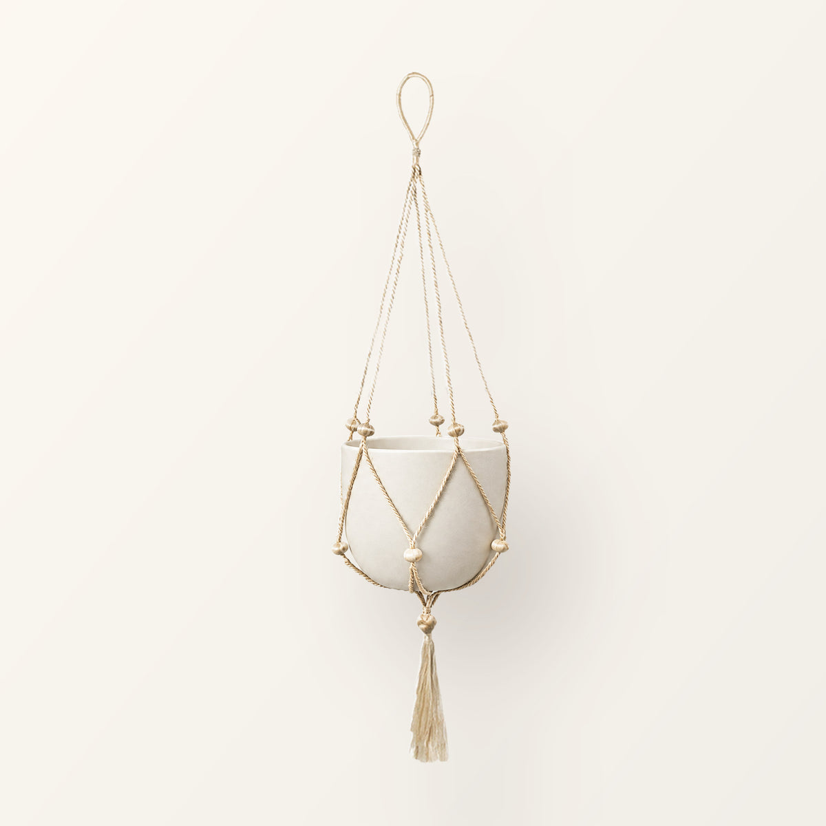 Nadu single jute macrame plant hanger with wooden beads and tassel, shown with a plain pot (not included)