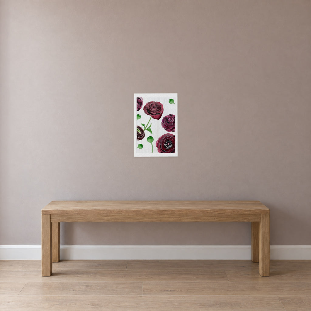 Unframed Black Ranunculus on Snow print, 13 x 19 in size, on a dusty-rose wall above a plain oak bench