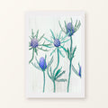 Purple Thistle on Snow unframed art print with a white border, shown flat on a plain background