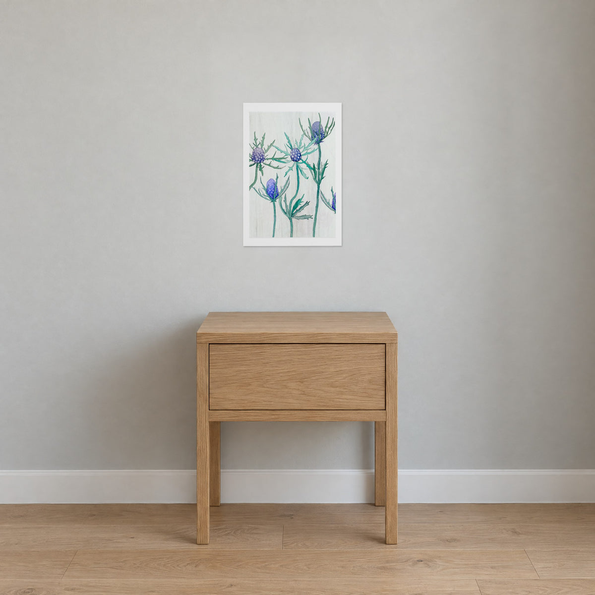 Unframed Purple Thistle on Snow print, 13 x 19 in size, on a pale grey wall above an oak nightstand