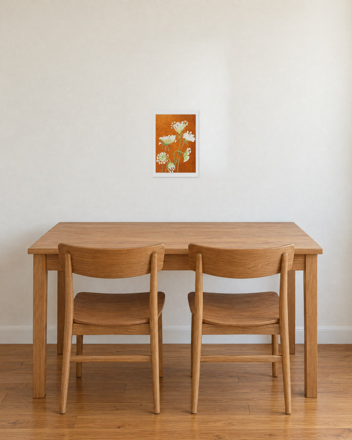 Unframed Queen Anne's Lace on Rusty Orange print, 13 x 19 in size, on a warm white wall above an oak dining table