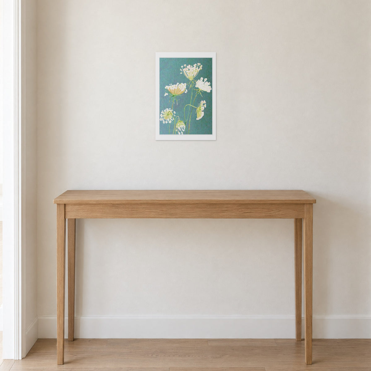 Unframed Queen Anne's Lace on Teal print, 13 x 19 in size, on a warm white hallway wall above a slim oak console
