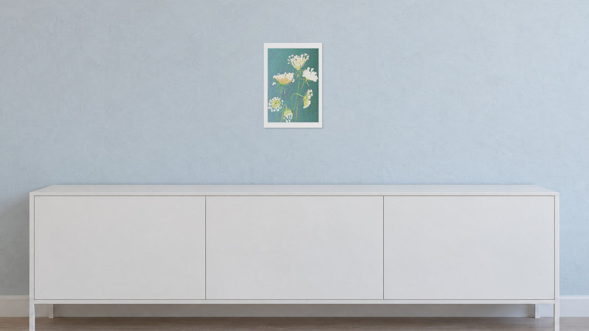 Unframed Queen Anne's Lace on Teal art print, 13 x 19 in size, on a pale grey-blue plaster wall above a white sideboard