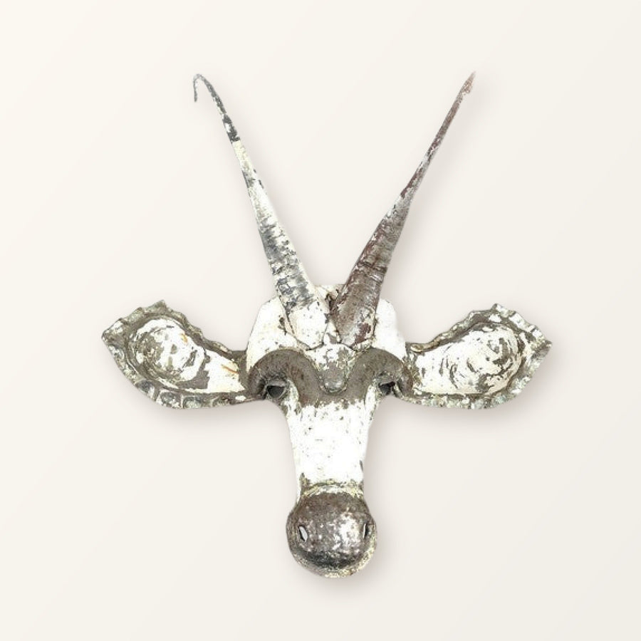 Sable antelope mask of recycled car tin, white paint worn back to bare metal, with two long horns; colour varies