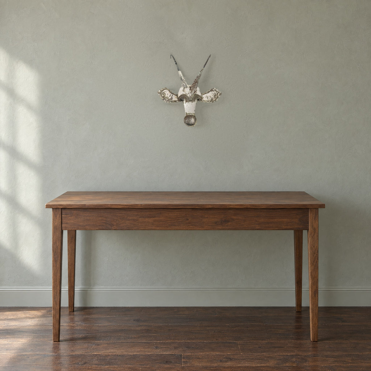 Sable recycled metal wall mask, 17 in wide, on a sage-grey wall above a 30 in high walnut desk