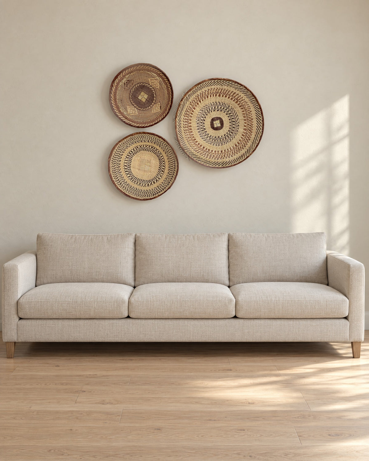 Tonga basket set of three hung above a plain linen sofa