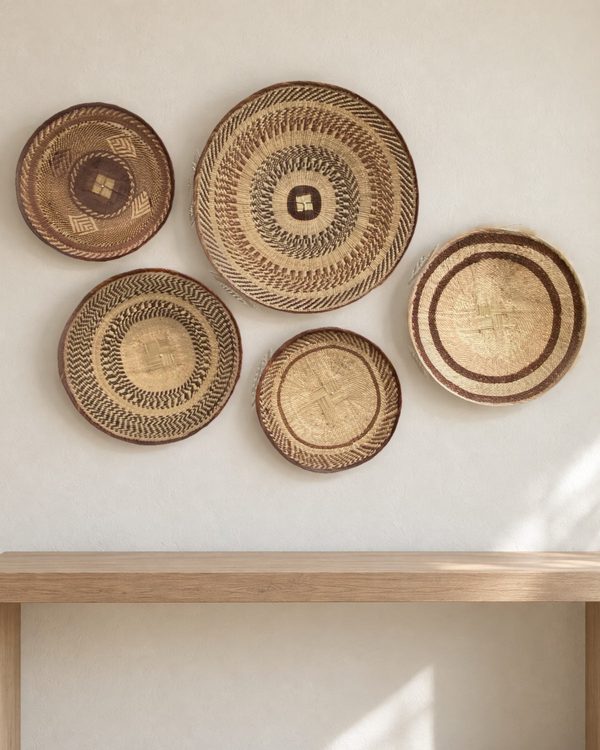 The five Tonga baskets of the set hung as a cluster on a warm white wall