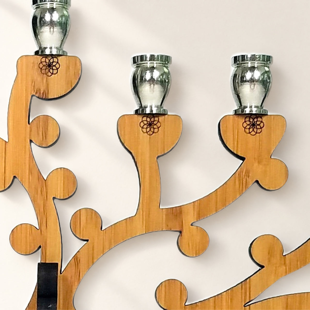 Close-up of the menorah's amber bamboo branches, engraved flower marks and nickel candle cups