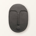 Ceramic wall mask in textured matte anthracite grey: an abstract face with a raised brow and nose